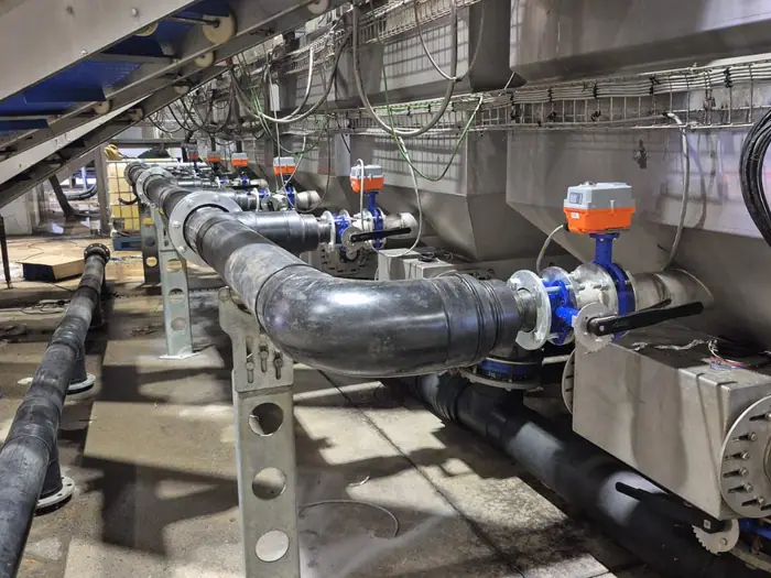 Actuated valve run under conveyor